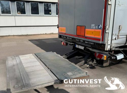 Truck with tarpaulin trailer and lifting platform